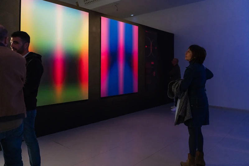 The Politics of Numbers — visitors viewing the paintings in the gallery